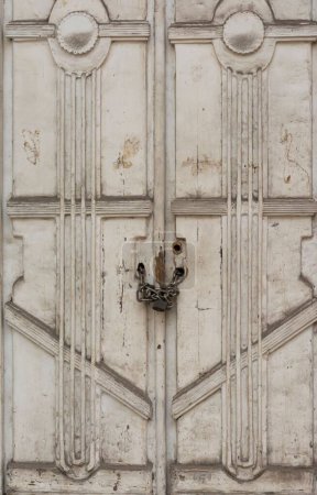 Téléchargez les photos : Plan vertical d'une vieille porte blanche en bois sculpté avec une chaîne et un cadenas - en image libre de droit