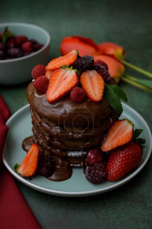 Photo for A closeup view of chocolate pancakes with strawberries topping - Royalty Free Image
