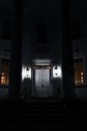 Téléchargez les photos : Un plan vertical d'une porte en bois la nuit avec des lumières - en image libre de droit