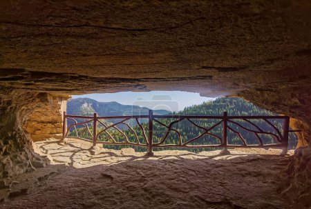 Téléchargez les photos : Une vue sur les forêts sur la colline par une journée ensoleillée depuis une grotte - en image libre de droit
