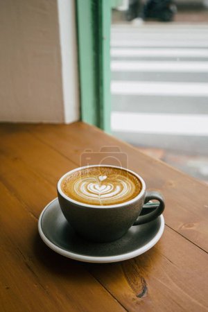 Téléchargez les photos : Un plan vertical de café avec tasse grise au-dessus de la table en bois dans un café - en image libre de droit