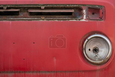 Photo for A closeup shot of the front part of an old vintage rusty red car on the blurred background - Royalty Free Image
