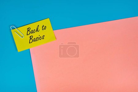 Foto de Un concepto de negocio. diseño de papel en blanco, clip de papel y nota amarilla con el texto: Back to Basics. - Imagen libre de derechos
