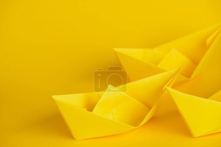 Foto de Un primer plano de tres barcos de origami amarillo sobre fondo amarillo - Imagen libre de derechos