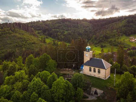 Photo for An aerial view of a church in greenery on a cloudy morning - Royalty Free Image