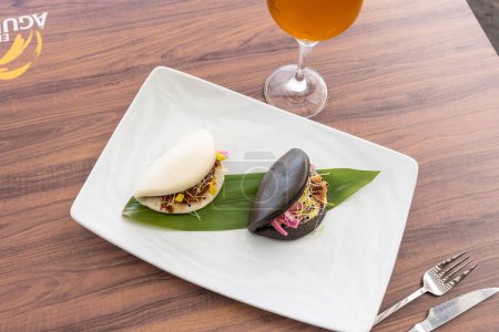 Téléchargez les photos : Les délicieux petits pains au bao sur l'assiette et un verre de bière sur la table - en image libre de droit