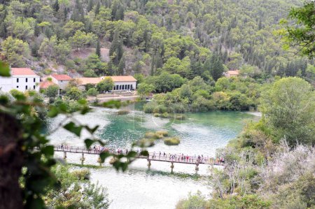 Photo for The bridge with tourists and Jaruga Hydroelectric Power Plant in Krka National Park in Croatia - Royalty Free Image