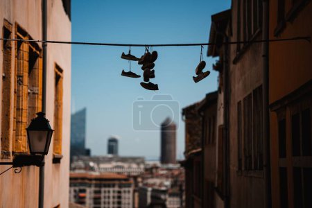 Foto de La silueta de zapatos colgantes en la ciudad de Lyon sobre el fondo borroso contra el cielo azul - Imagen libre de derechos