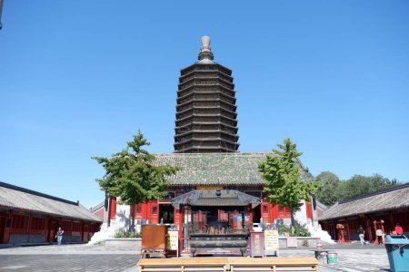 Téléchargez les photos : Un plan en angle bas de la pagode millénaire du temple Tianning à Pékin avec deux arbres verts devant elle, et les gens qui le visitent par une journée ensoleillée - en image libre de droit