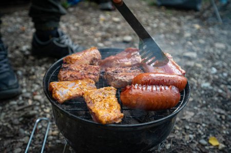 Téléchargez les photos : Un plan grand angle de viande grillée et de saucisses sur fond flou - en image libre de droit