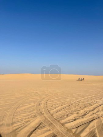 Téléchargez les photos : Une verticale du sable jaune lisse d'un désert arabe, Dubai safari désert sous un ciel bleu - en image libre de droit