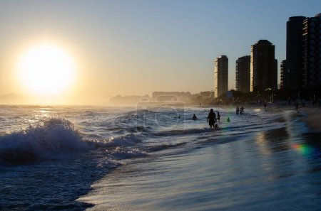 Téléchargez les photos : Une vue panoramique de la plage avec des vagues de mer à Barra da Tijuca au coucher du soleil, Rio de Janerio - en image libre de droit