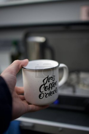 Photo for A vertical shot of a hand holding a cup of coffee - Royalty Free Image