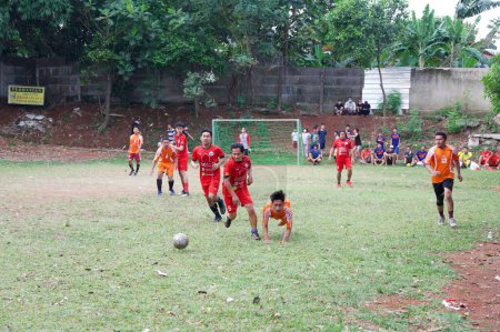 Photo for A group of boys playing football at the pitch celebrating Indonesia independence day - Royalty Free Image