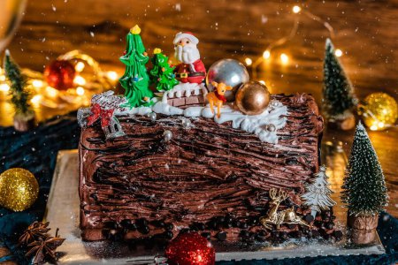 Téléchargez les photos : Un gros plan d'un gâteau de Noël au chocolat décoratif avec glaçage brun et garnitures de vacances - en image libre de droit
