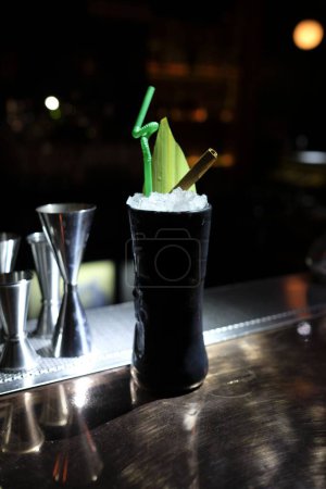 Téléchargez les photos : Un plan vertical d'un verre de cocktail sur une table avec des gabarits en arrière-plan - en image libre de droit