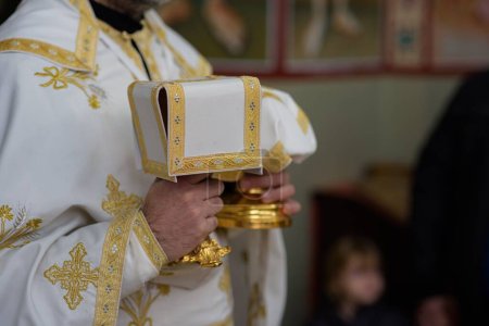 Téléchargez les photos : Gros plan d'un prêtre tenant des gobelets d'or lors d'une cérémonie - en image libre de droit