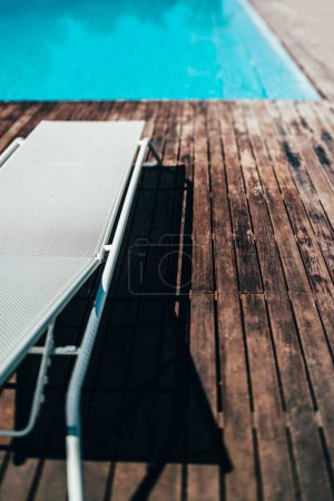 Téléchargez les photos : Le plan vertical d'une chaise pliante devant une piscine extérieure - en image libre de droit
