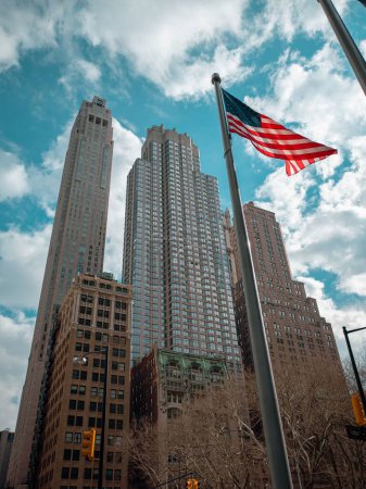Téléchargez les photos : Un plan vertical des bâtiments modernes et du drapeau américain à New York - en image libre de droit