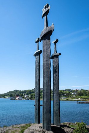 Téléchargez les photos : Un plan vertical d'épées en pierre avec un ciel bleu en arrière-plan à Hafrsfjord, Norvège - en image libre de droit