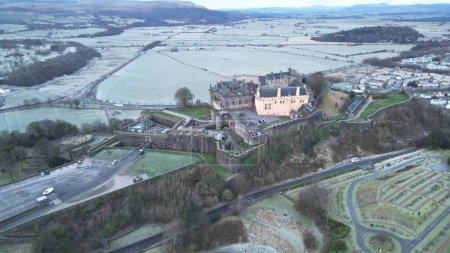 Foto de Una vista aérea de un histórico castillo de Stirling en Stirling, Escocia, en la colina, con un paisaje urbano, y campos de hierba en el fondo - Imagen libre de derechos