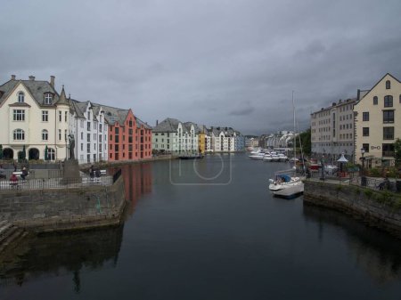Photo for A scenic shot of a river in Alesund, Norway, surrounded with residential buildings - Royalty Free Image