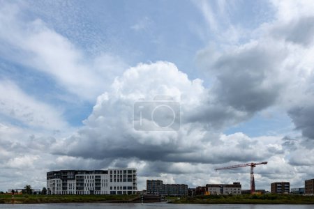 Téléchargez les photos : Vue panoramique large avec grand nuage dramatique au-dessus du chantier et architecture résidentielle néerlandaise contemporaine - en image libre de droit