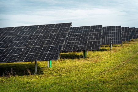 Foto de Los paneles del sistema solar en la gran central fotovoltaica en el campo verde - Imagen libre de derechos