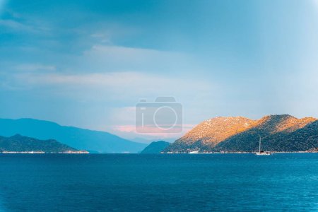 Téléchargez les photos : Un cliché fascinant d'un bateau naviguant dans les eaux turquoise avec des montagnes et des collines verdoyantes à l'horizon - en image libre de droit