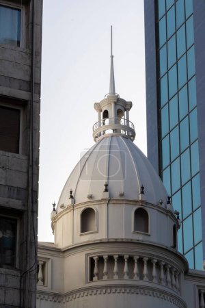 Téléchargez les photos : Un plan vertical d'un dôme d'église blanche avec des bâtiments modernes et des gratte-ciel en arrière-plan - en image libre de droit