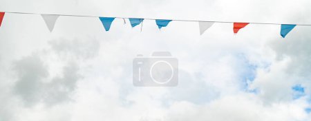 Foto de Un selectivo de decoraciones bunting contra el cielo azul con nubes blancas - Imagen libre de derechos
