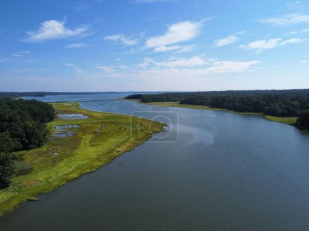 Téléchargez les photos : Vue aérienne d'un lac entouré d'arbres sous un ciel bleu - en image libre de droit