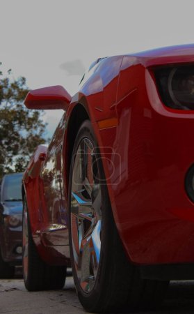 Photo for A vertical low angle shot of red Chevrolet Camaro car parked in the street - Royalty Free Image