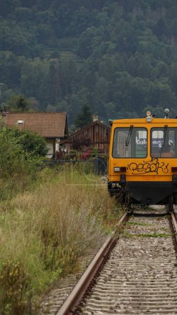 Foto de Un disparo vertical de un tren en las vías del tren con montañas de árboles verdes en el fondo - Imagen libre de derechos