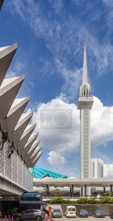 Téléchargez les photos : Le minaret de 73 mètres de haut de la mosquée nationale de Malaisie domine le toit de tuiles vertes de la salle de réunion principale.. - en image libre de droit