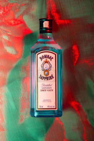 Téléchargez les photos : Un plan vertical d'une bouteille Bombay Sapphire Gin sous un éclairage rouge et bleu tamisé - en image libre de droit