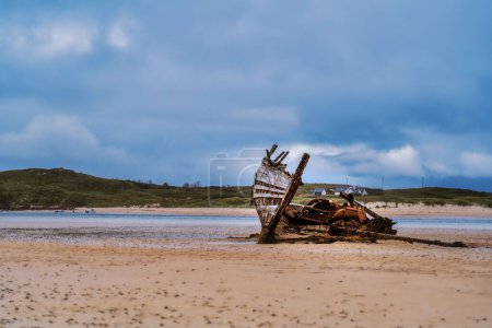 Photo for The view of an old broken ship details on the sand of a coast on a cloudy day in Donegal - Royalty Free Image