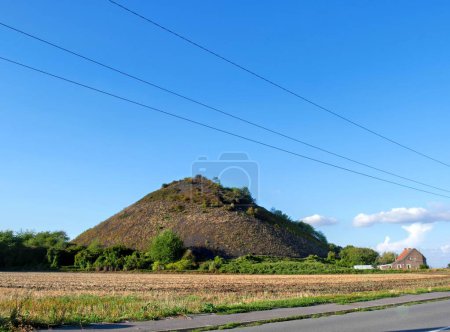 Foto de Un gran botín en el norte de Francia contra el cielo azul con una pequeña casa de campo al lado - Imagen libre de derechos