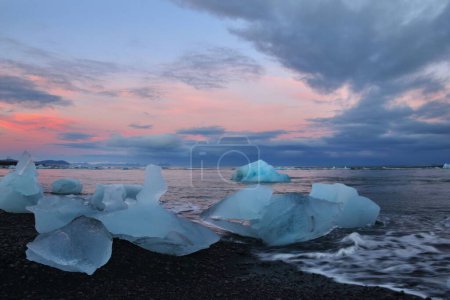 Foto de La vista de los icebergs en la superficie del agua al atardecer. Diamond Beach, Islandia. - Imagen libre de derechos