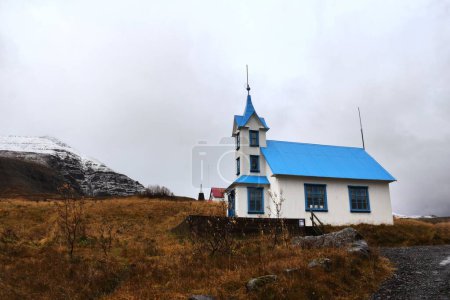 Foto de Una pequeña iglesia de montaña azul-blanca en el campo rural durante el otoño en Islandia - Imagen libre de derechos