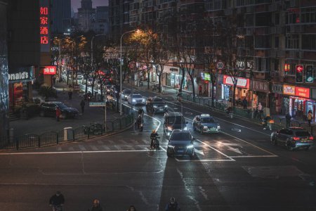 Téléchargez les photos : Un drone de voitures, de personnes, de lumières et d'architectures d'une rue locale la nuit dans la région de Tang Qiao, Shanghai, Chine - en image libre de droit