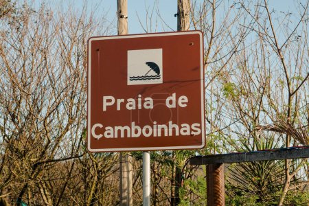 Photo for A closeup of the Portuguese sign of Camboinhas beach with greenery and sky behind it - Royalty Free Image