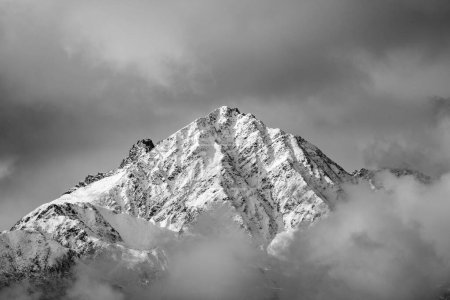 Téléchargez les photos : Un spectacle en niveaux de gris des Alpes enneigées culmine sous un ciel nuageux au Tyrol, en Autriche - en image libre de droit