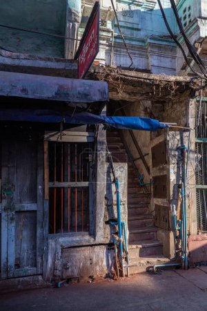 Photo for A stairway leads into the shadowy spaces of a dilapidated building in central Yangon, Myanmar. - Royalty Free Image