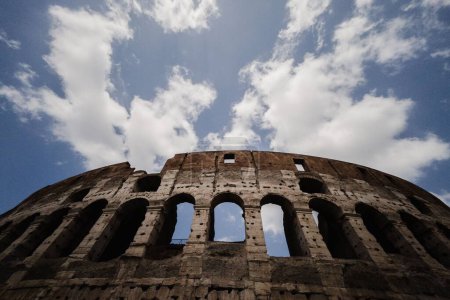 Foto de Una toma de bajo ángulo del Coliseo en Roma contra un cielo azul nublado - Imagen libre de derechos