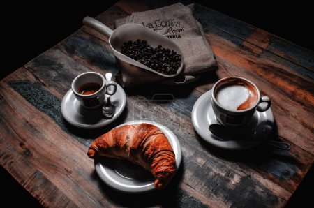 Foto de Un primer plano de dos tazas de café en la mesa de madera, granos de café alrededor - Imagen libre de derechos