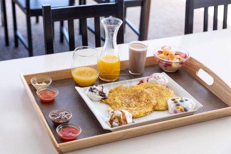 Photo for A closeup shot of a food tray filled with different foods and drinks placed on a wooden table - Royalty Free Image