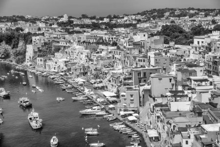 Photo for An aerial grayscale view of Procida Island with ships and beautiful buildings along the coastline - Royalty Free Image