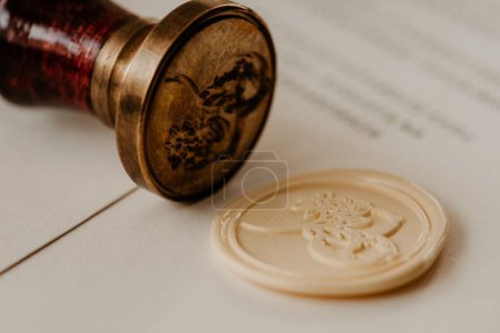 Photo for A closeup shot of a stamp kit and a white wax seal with papers in the blurred background - Royalty Free Image