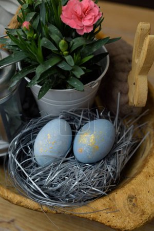 Foto de Una vista de cerca de los huevos de color azul en un nido decorado para la celebración de Pascua - Imagen libre de derechos